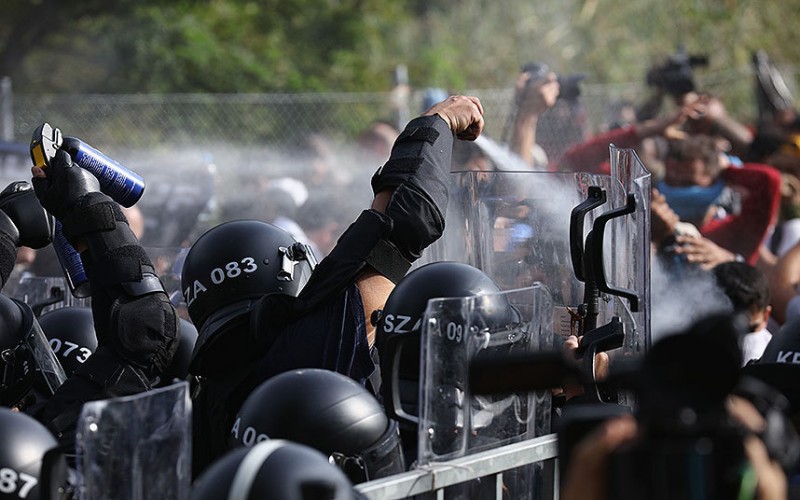 Mađarski policajci koriste sprej kako bi uspostavili kontrolu na zatvorenoj granici
